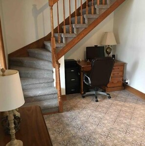 Staircase leads to a functional room with a desk and chair.