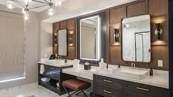 A modern bathroom with two sinks, large mirrors, and built-in shelves.