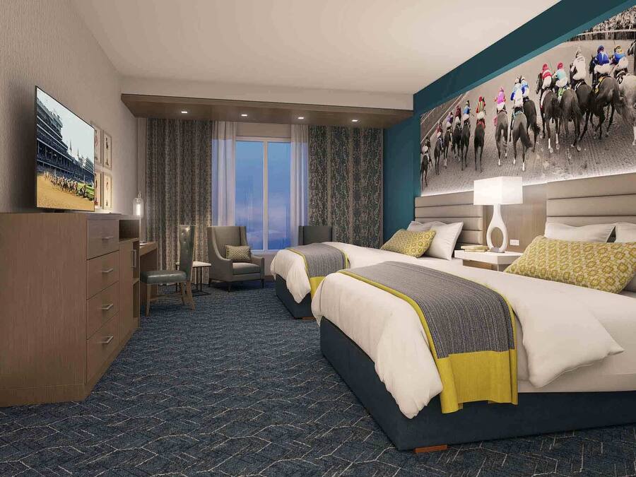 A hotel room with a large bed, a desk, a chair, a television, and a large poster on the wall.