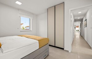 Een slaapkamer met een bed, een raam en een kledingkast.