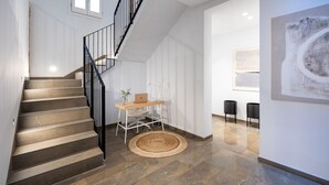 A modern interior with a staircase, a desk with a laptop, and a large abstract painting. - ChezmoiHomes Patio Zahorí 4 (Granada)