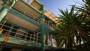 A multi-story building with balconies and large windows.