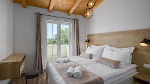 Une chambre à coucher avec un lit, un bureau, une chaise et une fenêtre avec des rideaux.