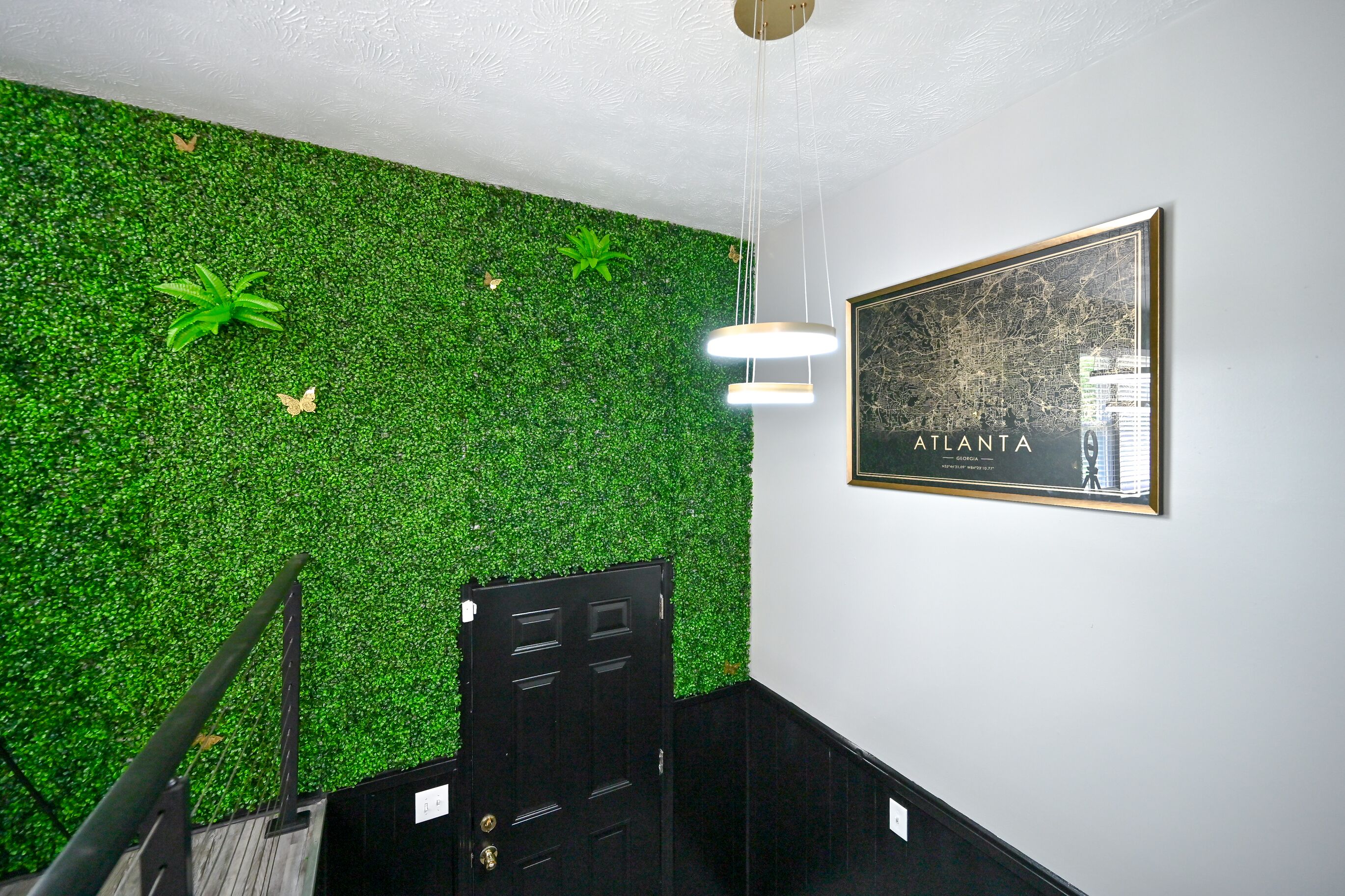 A staircase with a green wall and a framed map of Atlanta.