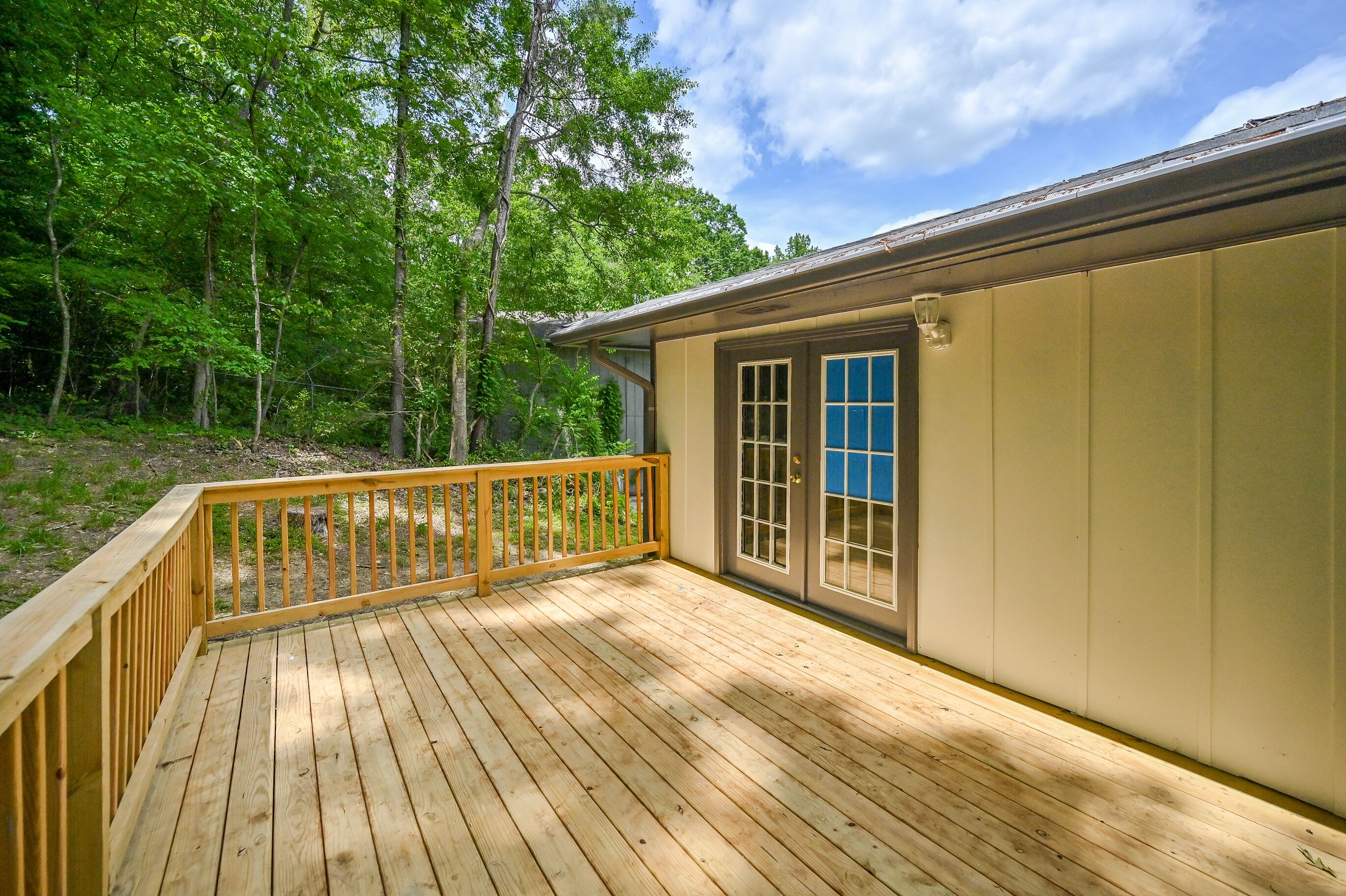 A wooden deck with a view of a forested area.