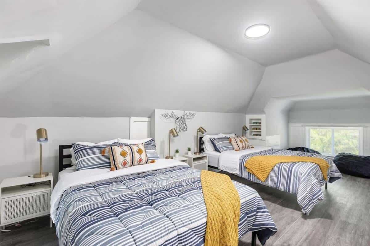 Een slaapkamer met twee bedden, een plafondlamp en een raam.