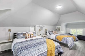 Une chambre avec deux lits, un luminaire au plafond et une fenêtre.