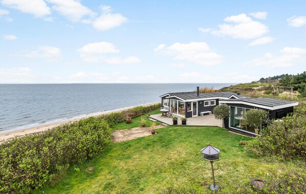 Ein modernes Küstenhaus mit Terrasse und Garten, mit Blick auf das Meer.