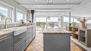 A modern kitchen with a central island, large windows, and a view of the sea. - Lovely home in Esbjerg V with house sea view (Esbjerg V)