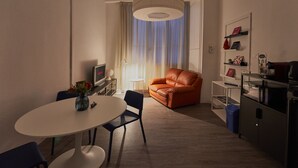 A modern living room with a round dining table, a leather sofa, and a large pendant light. - 2 minutes from rail station, bright flat in the centre on the town! CorsoItalia  (Arezzo)