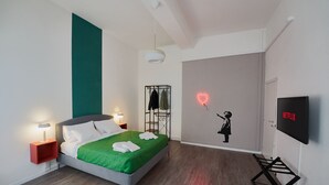 A modern bedroom with a bed, bedside lamps, a wall-mounted TV, and a neon sign. - 2 minutes from rail station, bright flat in the centre on the town! CorsoItalia  (Arezzo)