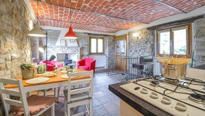 A rustic kitchen with a brick ceiling, stone walls, and a gas stove. - Awesome apartment in Monastero Bormida with house a panoramic view (Monastero Bormida)