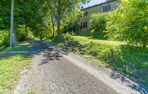 Surrounded by lush greenery, this traditional stone building offers a serene escape along a winding gravel path.