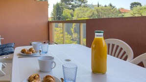 A breakfast table with croissants, a glass of orange juice, and a white cup. - LA BADINE Studio AirCo Pool for 2 By Sunset (Antibes)