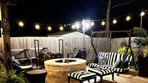 A backyard with a pool, outdoor seating, a fire pit, and string lights. - Beautiful Home W/Heated Pool- Sleeps 16, Pets & Small Events Allowed W/Approval  (Mansfield)