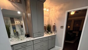 A modern bathroom with grey cabinets, a glass bowl sink, and a large mirror. - Beautiful Home W/Heated Pool- Sleeps 16, Pets & Small Events Allowed W/Approval  (Mansfield)