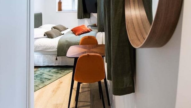 A modern hotel room with a bed, a desk, and a large mirror. - The O1 - room 1 - Opera - 26m² (Lyon)
