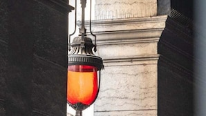 A street lamp with a red glass shade, mounted on a stone pillar, under an arched structure. - The O1 - room 1 - Opera - 26m² (Lyon)
