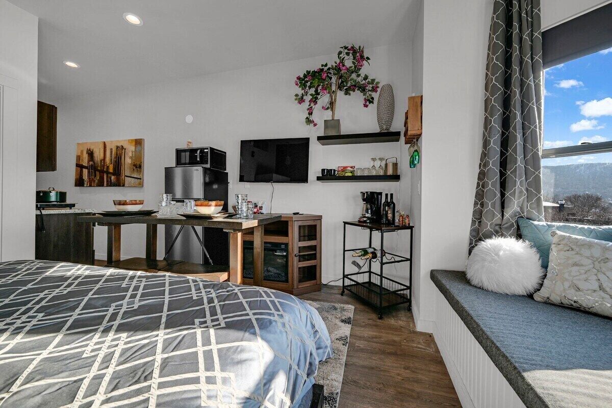 Une chambre moderne dotée d’un grand lit, d’un bureau intégré, d’une télévision et offrant une vue sur l’extérieur.