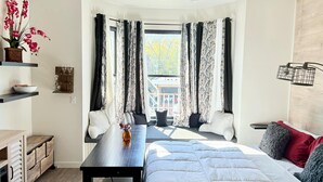 Ein modernes Schlafzimmer mit einem Bett, einem Schreibtisch und einem Fenster mit Vorhängen.