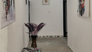 Ein Flur mit einer Bank, einer Vase und zwei Bildern an den Wänden.