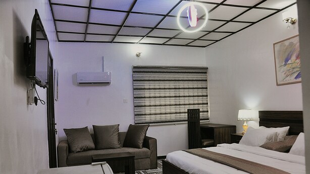 Ein Hotelzimmer mit Bett, Sofa, Schreibtisch und Fernseher.