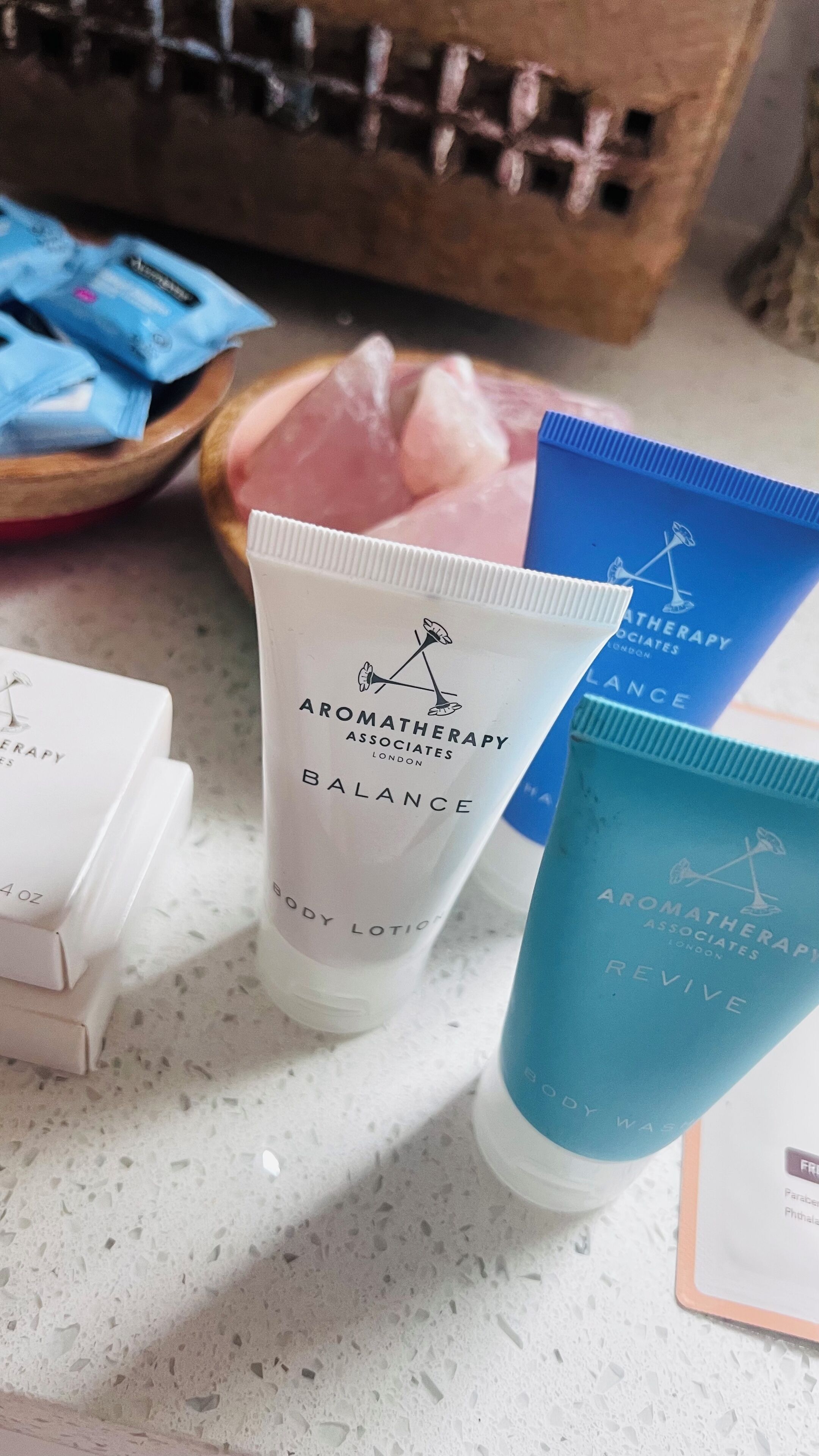 A countertop with various skincare products, including tubes and boxes labeled with 'Aromatherapy Associates London'.