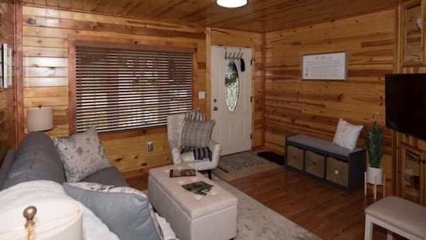 Ein gemütliches Blockhaus-Interieur mit Sofa, Hocker und einer Bank.