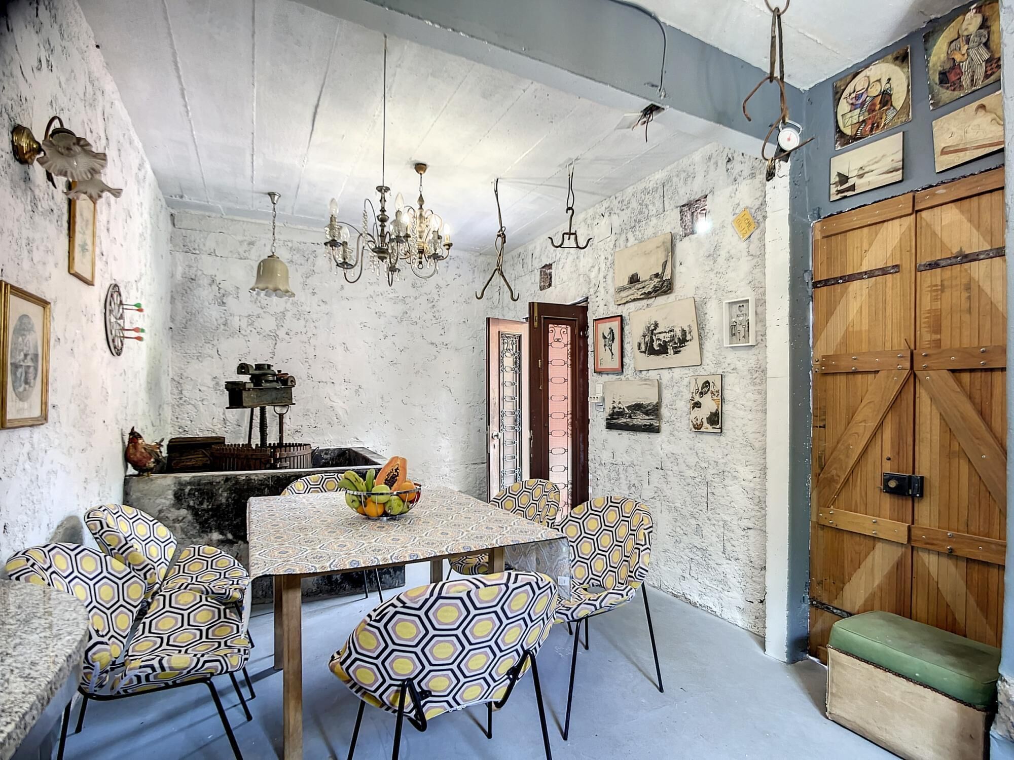 A dining area with a round table, patterned chairs, and a chandelier.