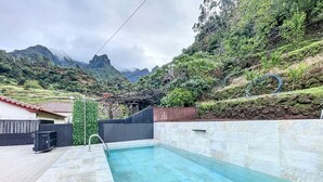 A swimming pool with stone tiles, surrounded by a garden with a view of mountains. - Avo Maria House by Atlantic Holiday (São Vicente)