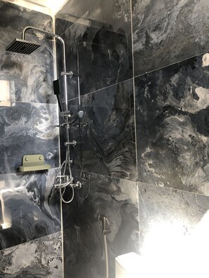 Standaard appartement | Badkamer | Een douche, handdoeken, toiletpapier