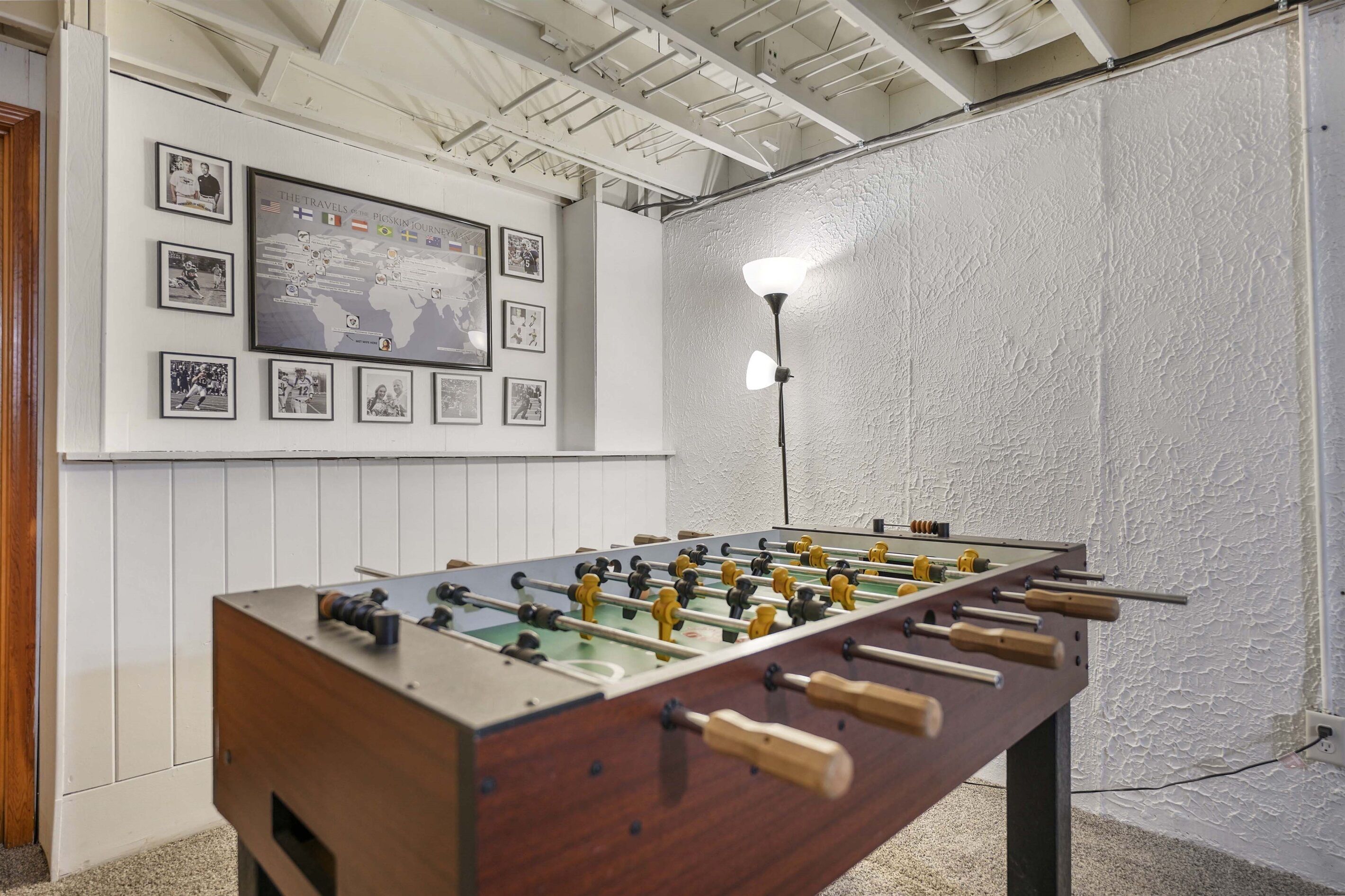 A foosball table in a room with white walls and a map on the wall.