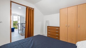 A bedroom with a bed, a wardrobe, and a door leading to a balcony. - Stunning home in Jurdani with WiFi (Jurdani)