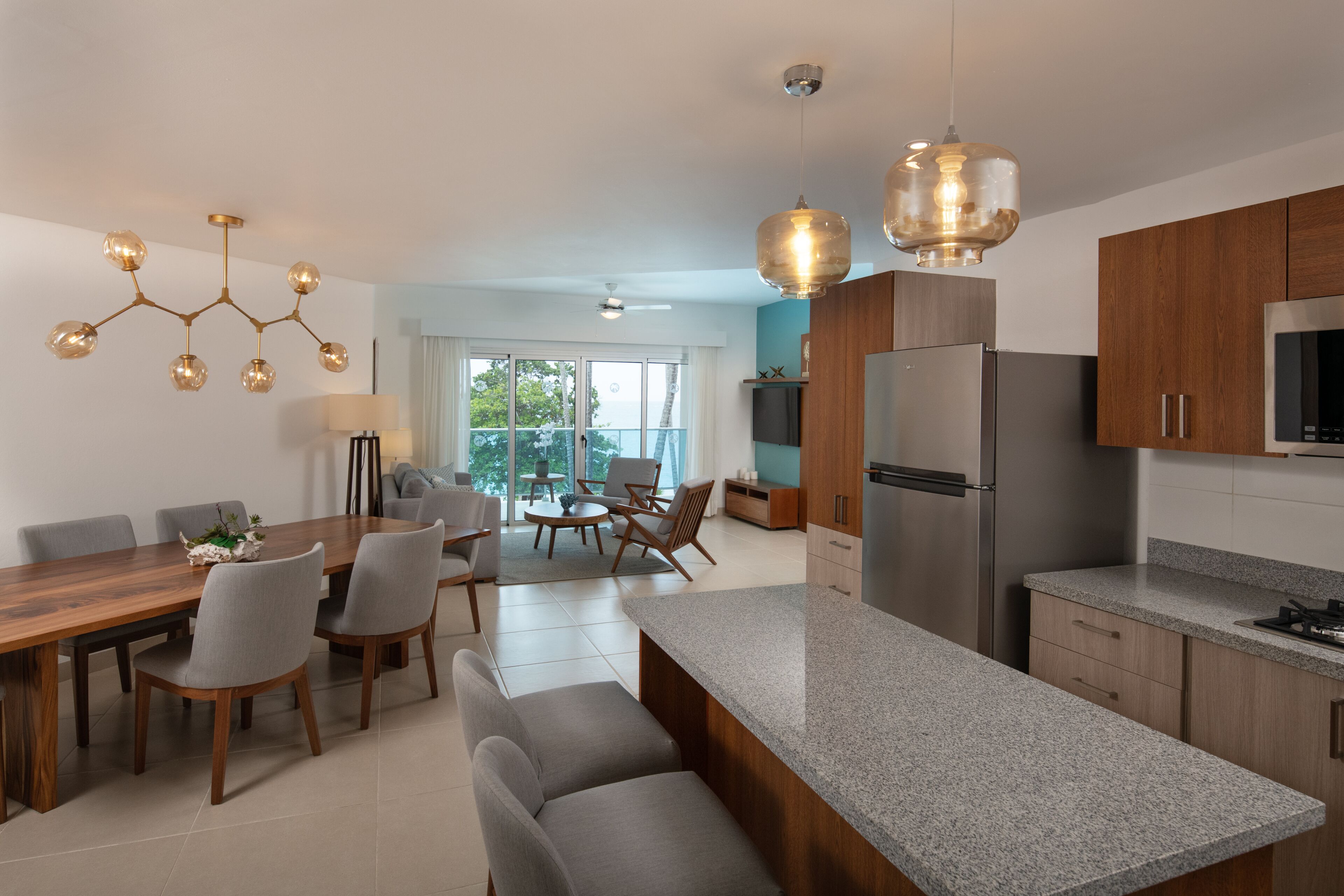 A modern kitchen with granite countertops, stainless steel appliances, and a dining area with a wooden table and chairs.
