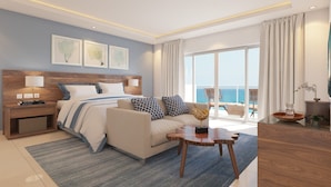 Una habitació d'hotel moderna amb un llit gran, un sofà, una taula petita i vista a l'oceà.