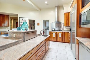 A modern kitchen with granite countertops, stainless steel appliances, and wooden cabinets.