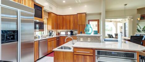 A modern kitchen with wooden cabinets, stainless steel appliances, and a central island with a sink.