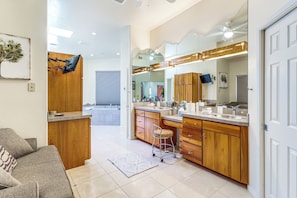 A modern bathroom with wooden cabinets, a large mirror, and a sink. - Mtn-View Oasis w/ Pool, Spa & Gym in Oro Valley! (Tucson)