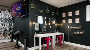 Une pièce avec un mur noir, des meubles blancs et des tabourets rouges.