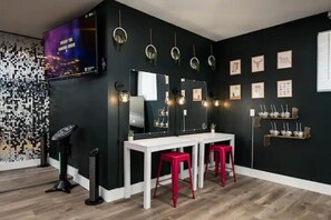 Een kamer met een zwarte muur, witte meubels en rode krukken.