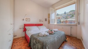 Une chambre à coucher avec un lit, une fenêtre et une vue sur des immeubles.