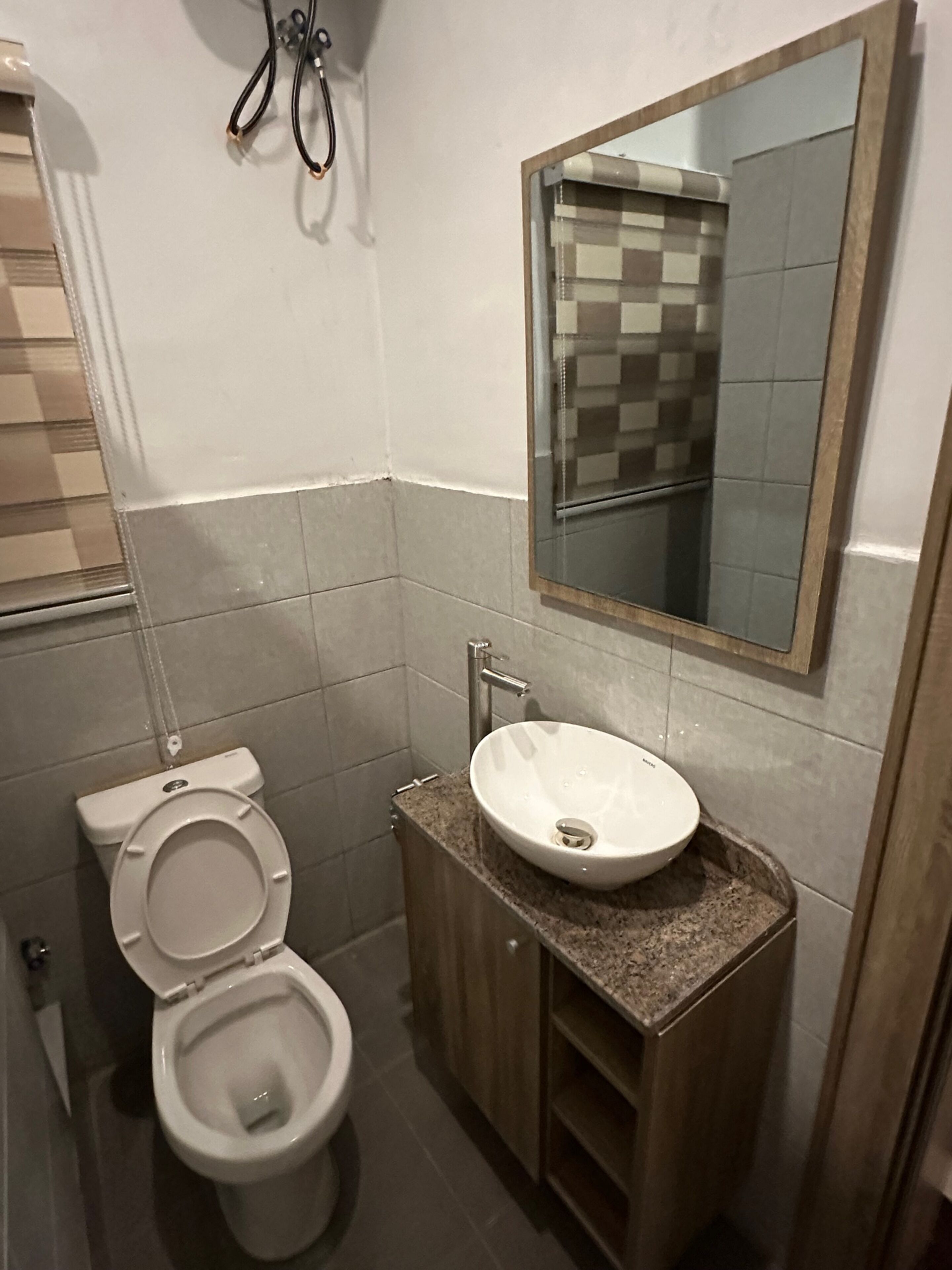 Une salle de bain avec des toilettes, un lavabo et un miroir.