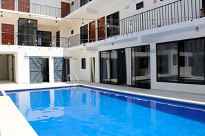 A modern indoor swimming pool with clear glass walls, a multi-level balcony, and a clean, contemporary design. - Acacia Hotel  (Tuxtla Gutierrez)