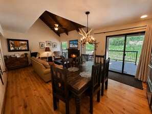 Un salón amplio con chimenea, una mesa de comedor y asientos cómodos.