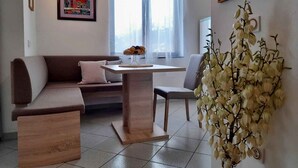 Una sala moderna con un sofá, una mesa de comedor y una planta decorativa.