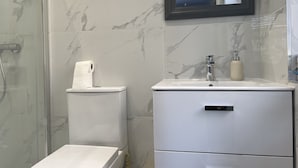 A bathroom with a toilet, a sink, and a mirror. - The Grand Bleu - Next to Tube station (London)