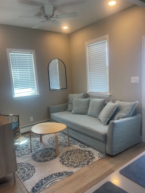 Relax in this inviting living room with a light blue sofa, round coffee table, and patterned rug.