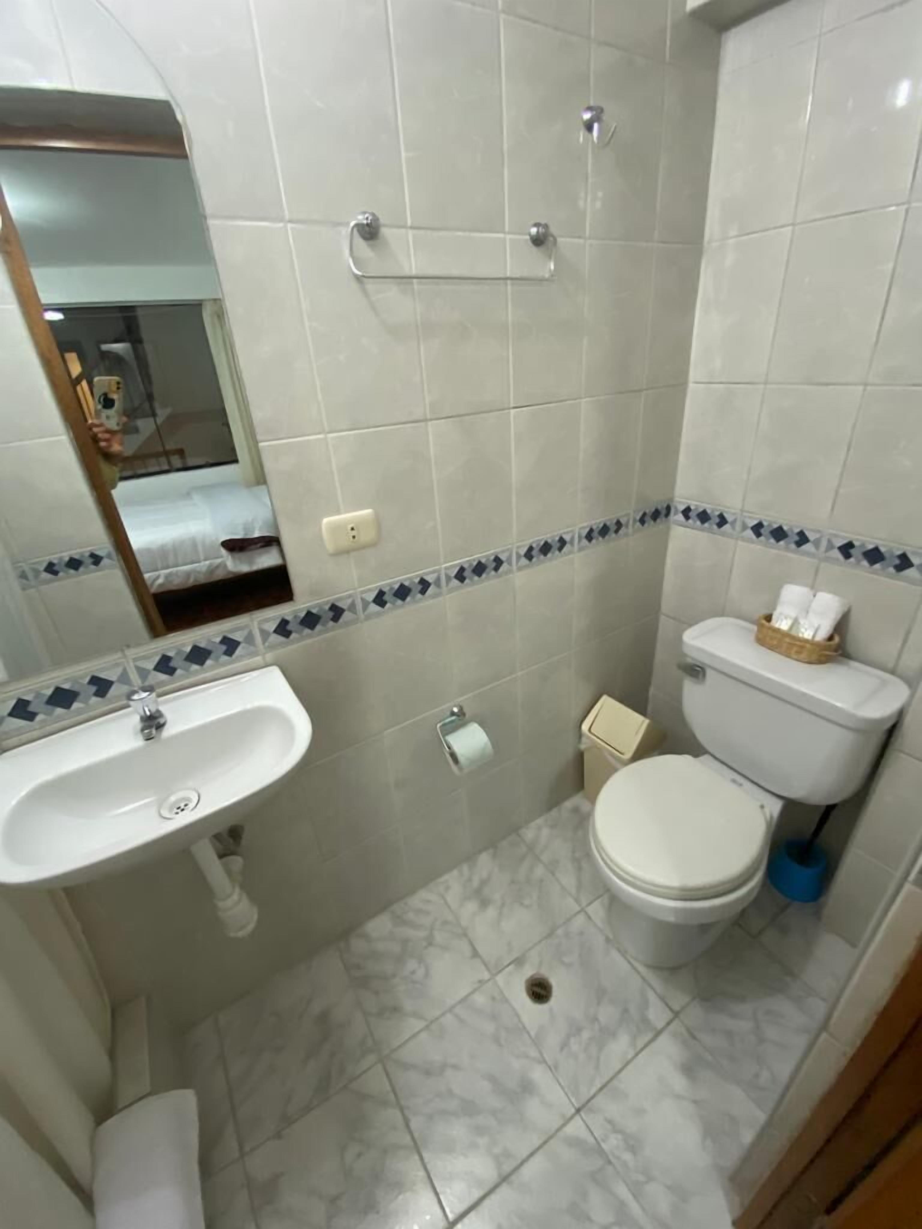 A bathroom with a sink, toilet, and shower.