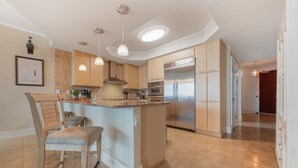 A modern kitchen with a central island, stainless steel appliances, and pendant lighting. - Cozy Three Bedroom Bayside Unit. Complimentary Boat Slip. (Orange Beach)