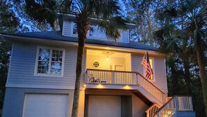 A two-story house with a front porch, a garage, and a staircase leading to the upper level.